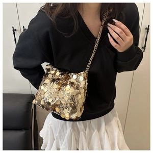 Detailed close-up of a glamorous gold sequin crossbody bag with a slim metal chain strap