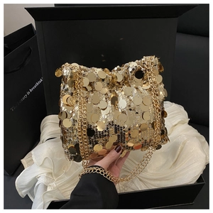 Close-up of golden sequin bucket bag with chain strap on elegant silk background