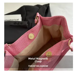 Detailed view of pink textured tote bag with a golden magnetic snap closure and beige lining