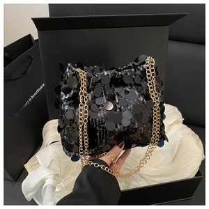 Close-up of black sequin bucket bag with shiny texture and golden metal chain strap