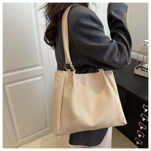Detail of canvas tote bag showing the textured fabric and gold ring strap connector