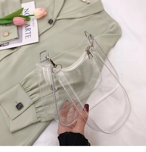 Détail du sac sous le bras en PVC transparent avec zip argenté et bandoulière chic