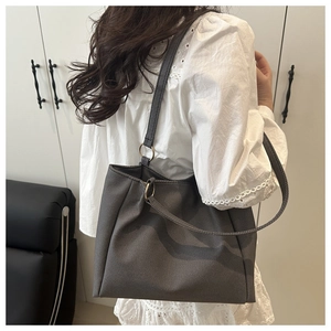 Close-up of charcoal gray canvas tote bag with metal ring detail on shoulder straps