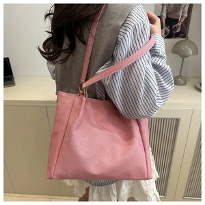 Close-up of pink tote bag showing fine woven texture and gold metal ring strap detail