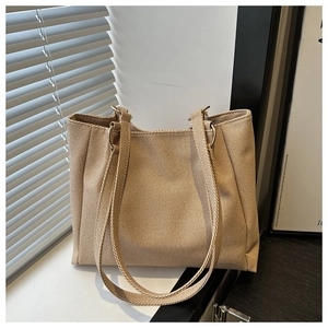 Detail of beige canvas tote bag with metal ring strap connectors for daily commute