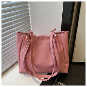 Detailed view of pink striped canvas tote bag with silver metal rings and double straps