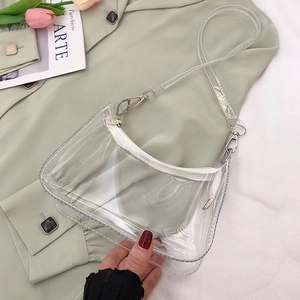 Sac à main en PVC transparent avec détails argentés sur un fond de veste blazer vert pastel