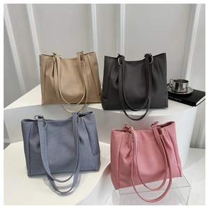Detail view of four textured tote bags in khaki, gray, blue and pink on display