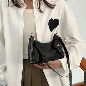 Sac à épaule noir brillant en PVC pour femme porté avec une tenue décontractée