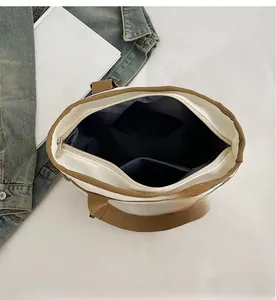 Detail view of large canvas tote bag showing inner navy lining and secure zip closure