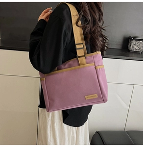 Detail of purple canvas tote bag with khaki straps and leather logo patch on the side
