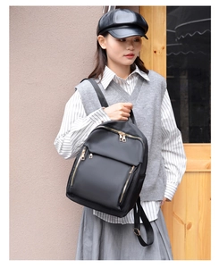 Detail of a lightweight black nylon backpack with a stylish gold zipper pocket and side pockets