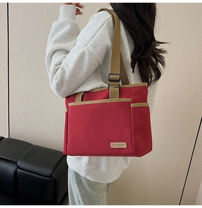 Detail of red canvas tote bag with khaki wide strap and Fashion & Bags woven label