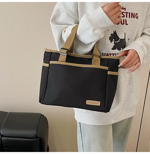 Detail der Canvas-Tragetasche mit praktischen Vordertaschen und Leder-Logo-Etikett