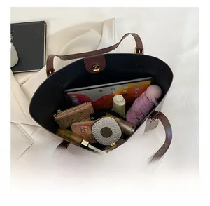 Interior view of brown leather tote showing spacious capacity and magnetic metal closure