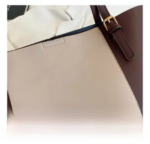 Detail of stitched two-tone leather tote bag with elegant golden fashion lettering