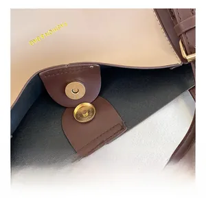 Detailed macro view of gold magnetic clasp and premium leather lining on shoulder bag
