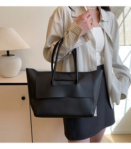 Bolso tote minimalista de cuero negro mostrado en un interior elegante para el uso diario