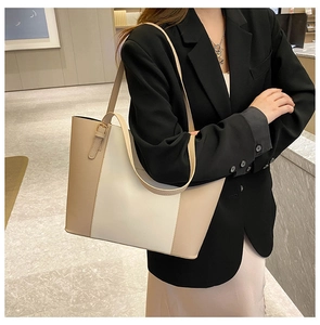 Detail of minimalist cream and khaki leather tote bag with long adjustable strap