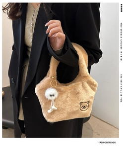 Détail du sac seau en peluche beige avec broderie ours et breloque monstre mignonne