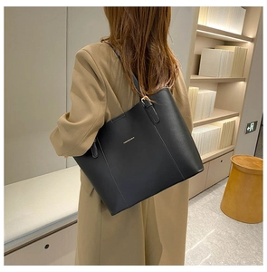 Detail of black leather tote bag with adjustable strap and Fashion & Bag lettering