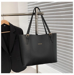 Detail of black leather tote bag with gold hardware and Fashion & Bag lettering