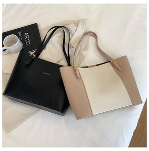 Detail of minimalist faux leather tote bags in black and beige with gold hardware
