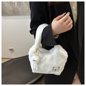 Détail du sac à main en peluche blanche avec broderie ours et un charmant pompon