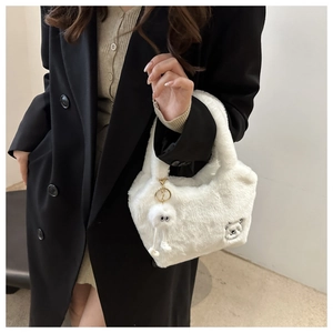 Détail du sac cabas en fausse fourrure blanche avec broderie ours et breloque en peluche