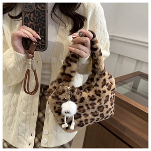 Gros plan du sac à main en fausse fourrure léopard avec un pendentif pelucheux