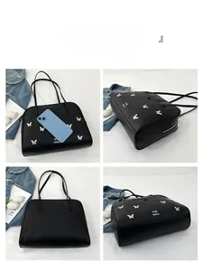Détails du grand sac cabas noir avec charms papillons argentés et cuir mat souple