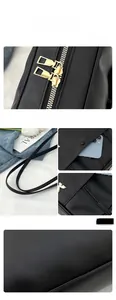 Détails du sac cabas noir avec fermetures éclair dorées et compartiment pour téléphone