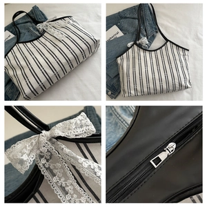 Detalle de bolso tote de lona a rayas con lazo de encaje blanco y cremallera metálica
