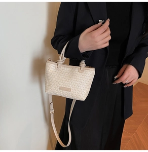 Détail de la texture tressée et de l'anse en similicuir nouée sur le sac beige