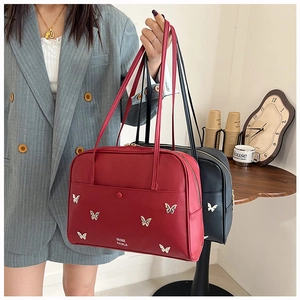 Détail de sacs fourre-tout tendance en rouge et noir avec papillons en métal argenté