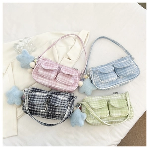 Détail de sacs à bandoulière en tissu à carreaux avec poches avant et breloques étoiles