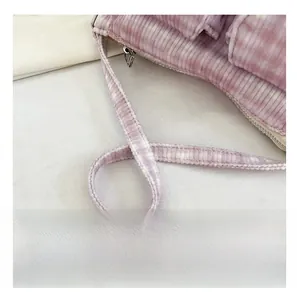 Détail du sac bandoulière en velours côtelé mauve montrant la sangle et le zip en métal