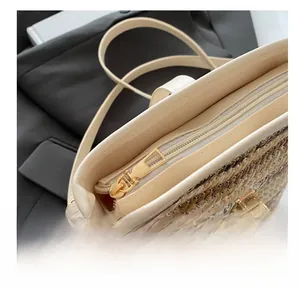 Close-up of smooth gold zipper and beige PU woven texture on a stylish bucket bag