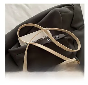 Detailed shot of woven texture and gold metal buckle on a brown PU leather shoulder bag