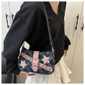 Close-up of star denim shoulder bag with pink leather trim and silver chain strap