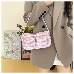 Gros plan du sac porté épaule en velours côtelé rose avec deux poches et zip argenté