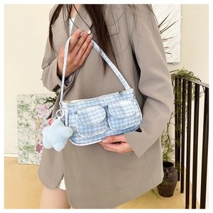 Détail du sac à bandoulière à carreaux bleu clair avec une étoile en peluche sur un modèle