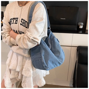 Detail der blauen Denim-Hobo-Tasche mit Seitentasche und verstellbarer Metallschnalle