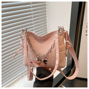 Détail du sac à bandoulière plissé rose avec chaîne argentée et breloque en forme de papillon