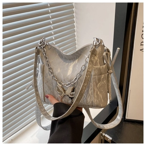 Détail du sac argenté métallisé avec texture froissée chaîne en métal et pendentif papillon