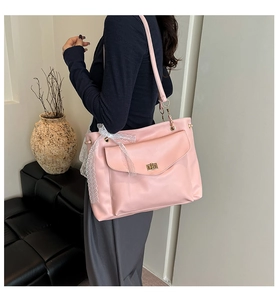 Sac bandoulière rose en cuir avec fermoir doré et ruban décoratif en dentelle