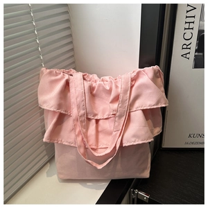 Detalle de bolso tote de tela rosa con elegantes bordes de volantes y textura suave