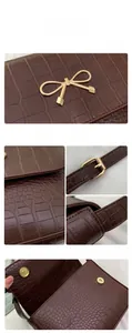 Detalle de textura de cocodrilo marrón y cierre de lazo dorado en el bolso de moda