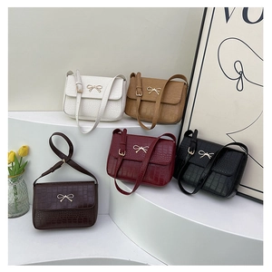 Détail de cinq sacs bandoulière en cuir gaufré crocodile avec boucle nœud dorée