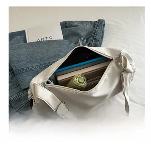 Macro view of white nylon shoulder bag interior showing large capacity for laptop and umbrella